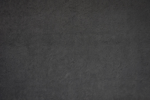 Close-up of black concrete wall texture background.