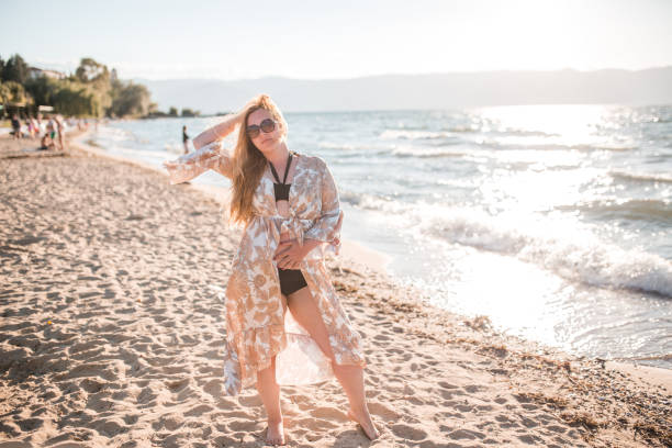 istock Confident plus size woman with sunglasses on the beach 1385607237