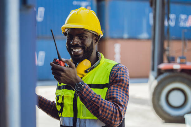 istock happy worker working in port logistic cargo industry with radio command 1385612276