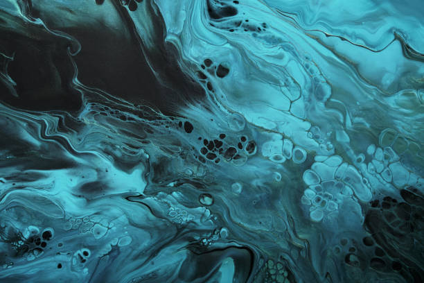 istock Fluid Art. Fluorescent blue waves with golden particles on black background. Marble effect background or texture 1385612402