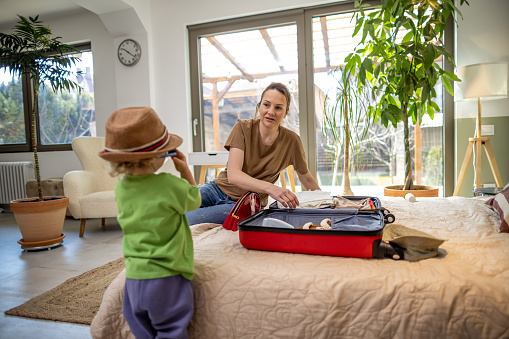 Mother And Son Packing  Suitcase For Vacation
