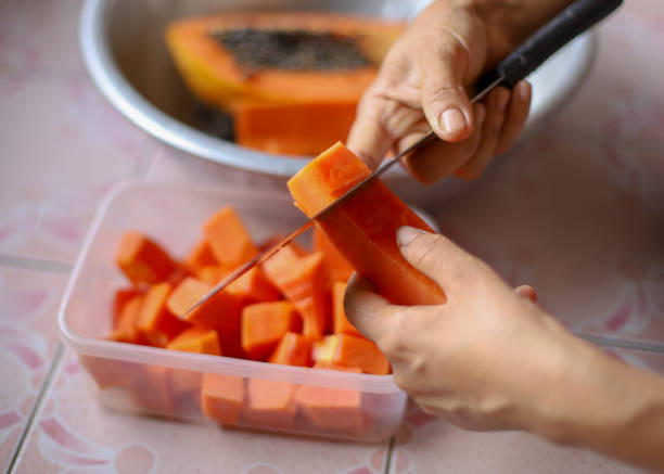 istock Hands slicing ripe papaya 1385617142