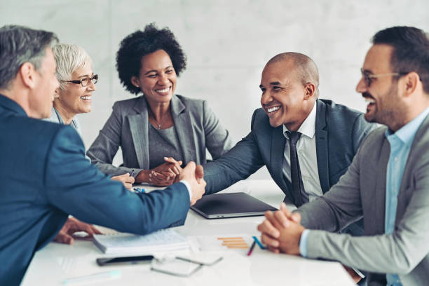 istock Businessmen shaking hands across the table 1385618499