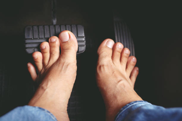 uomo che calpesta il freno dell'auto per rallentare, fermare l'auto sia normalmente che bruscamente, trasferire il peso per premere le ruote anteriori per afferrare la strada e girare più stabile - barefoot foto e immagini stock