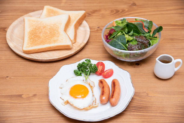 istock Fried egg, sausage, toast and salad morning set 1385620043