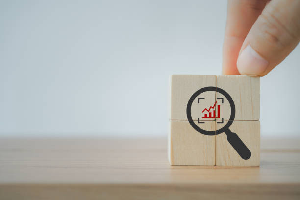 istock hand hold the  cubes with magnifying glass and cropped object symbols with increase graph inside for Identify and clarify concept, market and customer target and focusing 1385622001