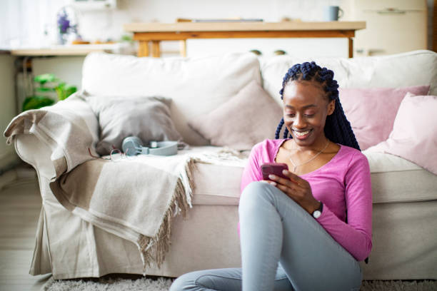 istock Young African woman using mobile at home 1385625379