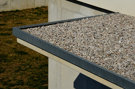 gravel mulch on the roof of a flat green roof. covers and protects layers of insulation and has a decorative effect. roof without plants above the entrance to the building, substrate, inert