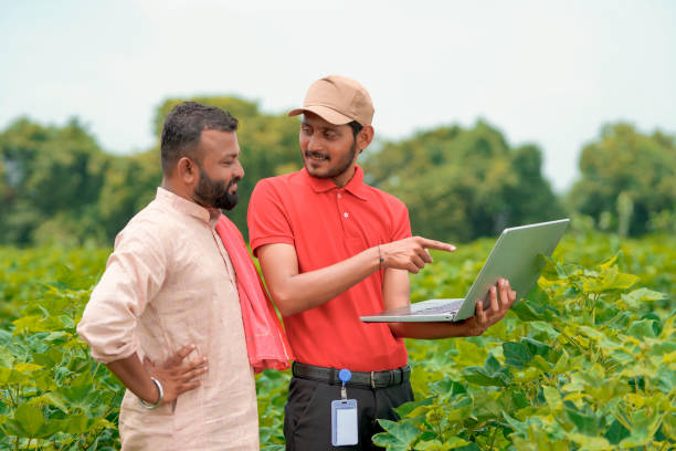 young indian agronomist showing information to farmer in laptop at green agriculture field. - thumps up imagens e fotografias de stock