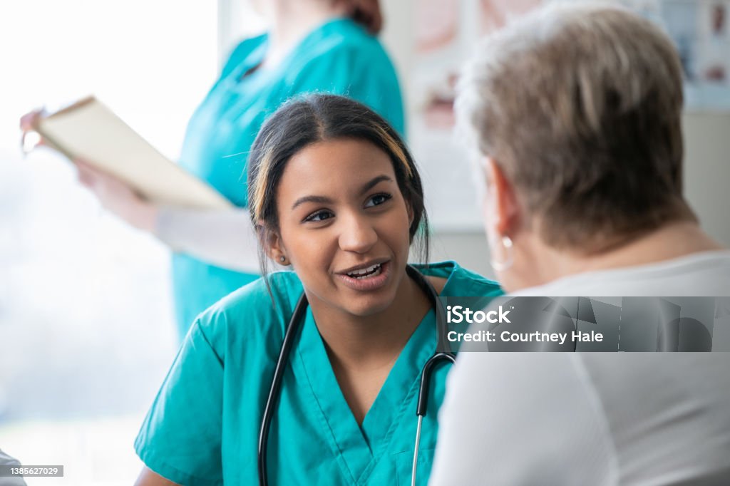 Cancer patient meets with diverse group of doctors, nurses, and healthcare providers in hospital to discuss treatment plan Healthcare And Medicine Stock Photo
