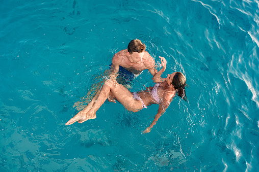 High angle view of young couple communicating while spending a summer day in the sea. Copy space.