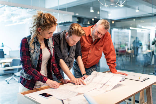 istock Building contractors examining blueprints in the office. 1385633568