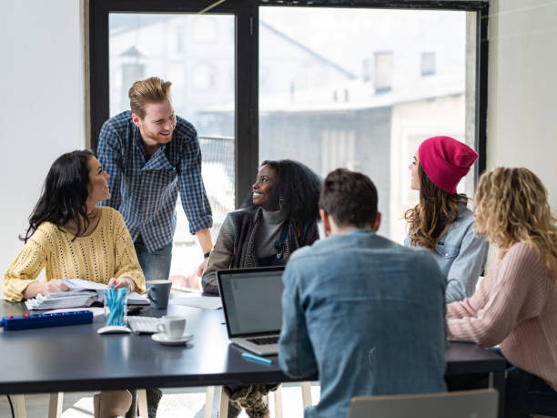 istock Young happy freelancers talking while working at casual office. 1385633689