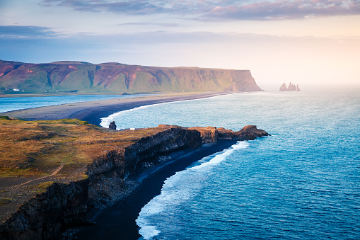 Great view on Kirkjufjara beach and sunny hills. Popular tourist attraction. Picturesque and gorgeous scene. Location place Sudurland, cape Dyrholaey, Vic village, South Iceland, Europe. Beauty world.
