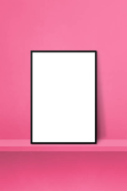 istock Black picture frame leaning on a pink shelf. 3d illustration. Vertical background 1385634504