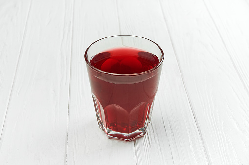 Berry compote in a clear glass on a white wooden background
