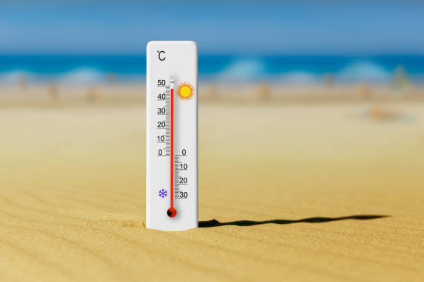Sea coast at hot summer day. Thermometer in the sand shows plus 48 degrees celsius stock photo