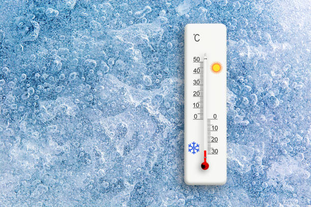 Top view of natural ice texture with celsius scale thermometer. Ambient temperature minus 27 degrees stock photo