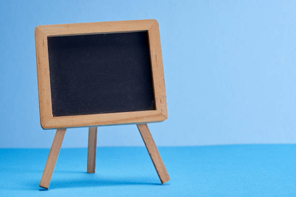 pequeno quadro-negro no fundo azul - easel blackboard isolated wood - fotografias e filmes do acervo