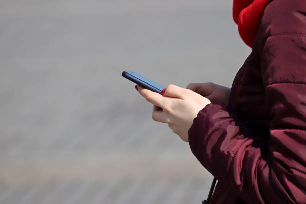 istock Woman standing with a smartphone on the street 1385640118