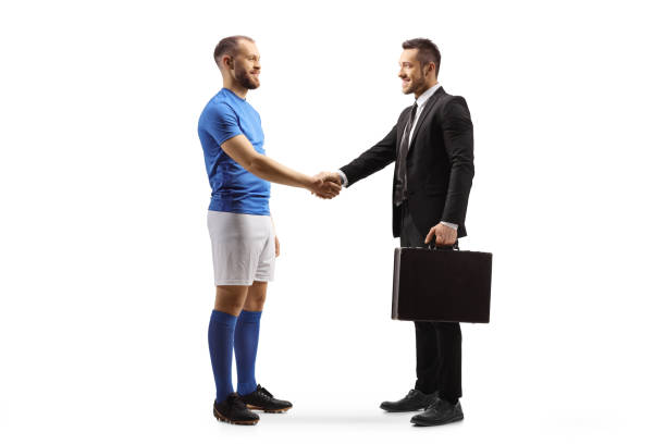 istock Football player and a businessman shaking hands 1385642152