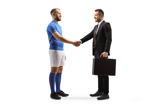 Football player and a businessman shaking hands isolated on white background