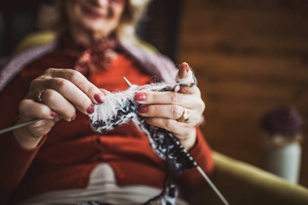 istock Close up of mature woman knitting. 1385646627