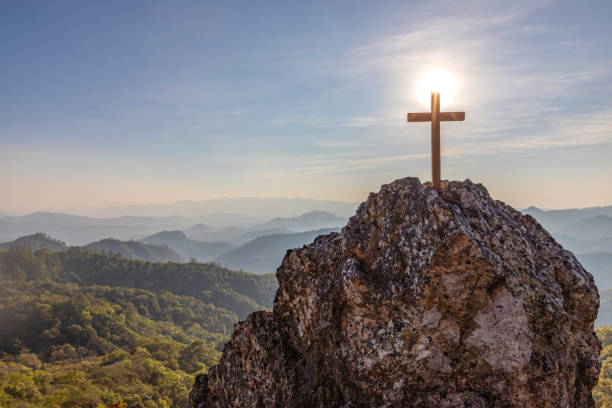 istock Wooden Crucifix symbol on top rock mountain on the sunset sky background 1385646635