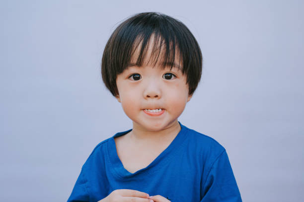 Portrait headshot Asian Chinese boys looking at camera with whit background biting lip