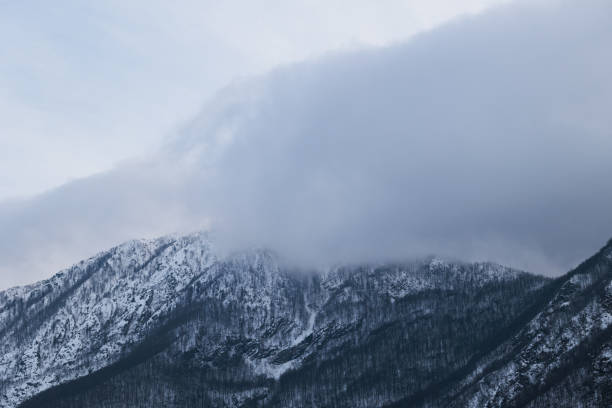 istock mountain range partially covered by snow and by huge gray clouds at sunset during winter season 1385654372