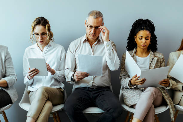 biznesmeni siedzący w kolejce na rozmowę kwalifikacyjną - unemployment waiting in line waiting room interview zdjęcia i obrazy z banku zdjęć