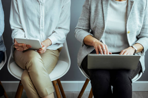 zbliżenie grupy nierozpoznawalnych biznesmenów siedzących w kolejce do wywiadu - unemployment waiting in line waiting room interview zdjęcia i obrazy z banku zdjęć