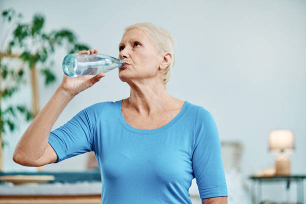 istock elderly woman drinks water after a morning workout 1385662898