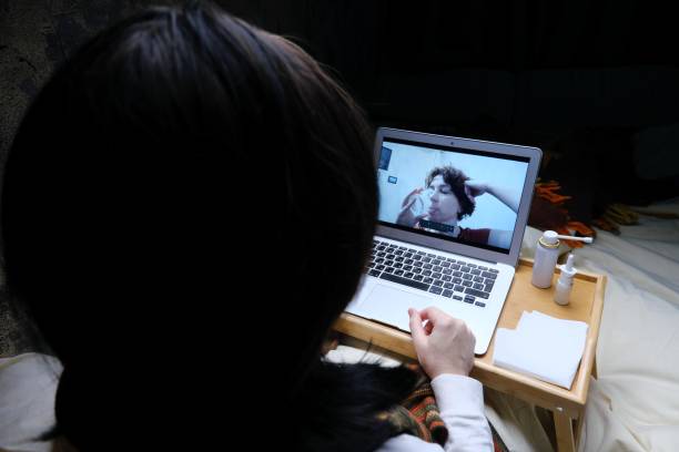 istock Woman is videocalling her friend while staying in bed with flu 1385664547