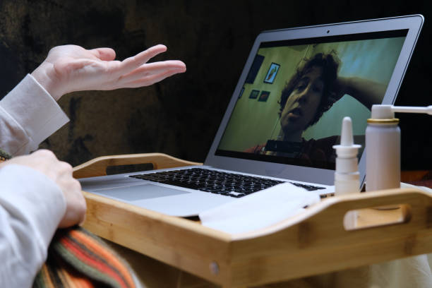 istock Woman is videocalling her friend while staying in bed with flu 1385664716