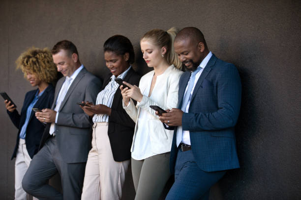 istock People using their phones whilst waiting outside 1385666877