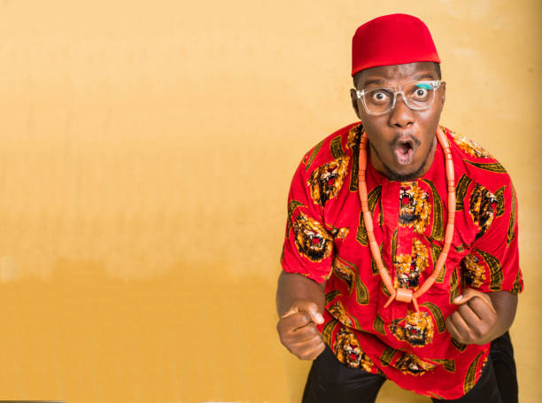 ibibo calabar akwa ibom homme culturellement habillé faisant une pompe à poing - nigeria african culture dress smiling photos et images de collection