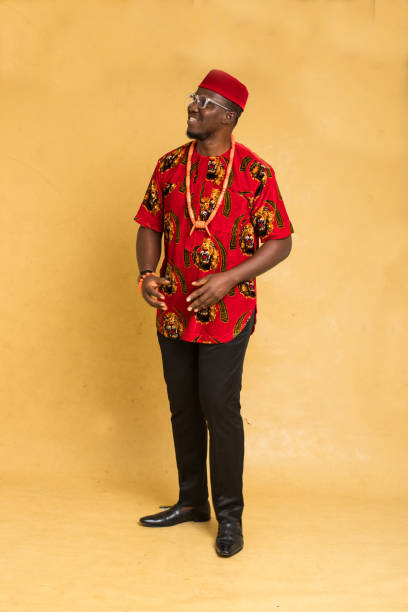 igbo tradicionalmente vestido homem de negócios de pé olhando para o lado - indigenous culture nigerian culture african descent nigeria - fotografias e filmes do acervo