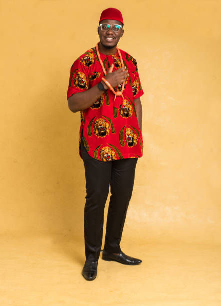 igbo traditionally dressed business man standing and adjust beads - nigeria african culture dress smiling imagens e fotografias de stock