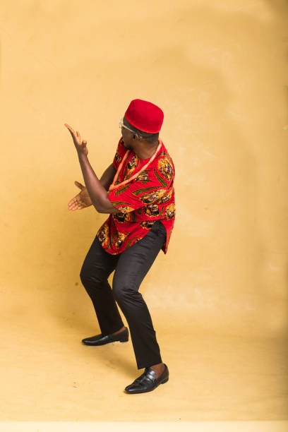 igbo tradicionalmente vestido homem de negócios mostrar produto lateral imaginário - indigenous culture nigerian culture african descent nigeria - fotografias e filmes do acervo