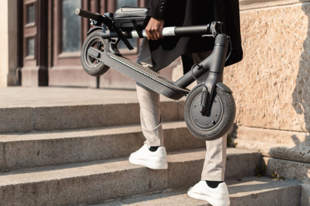Unrecognizable young man carrying a push scooter