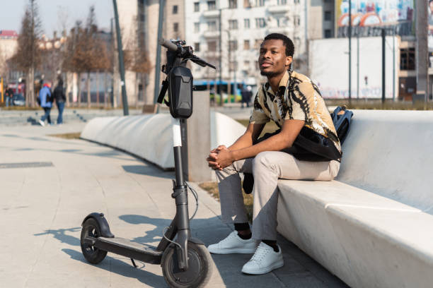 istock Young Afro man taking a break while traveling on a push scooter 1385668079