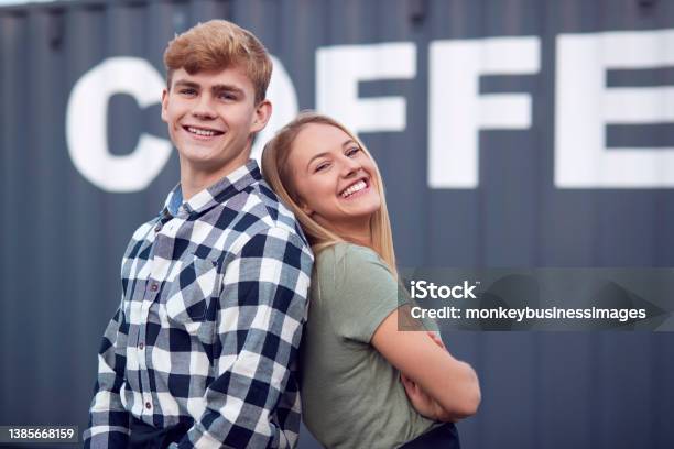 Portrait Of Male And Female Interns At Freight Haulage Business Standing By Shipping Container Stock Photo - Download Image Now