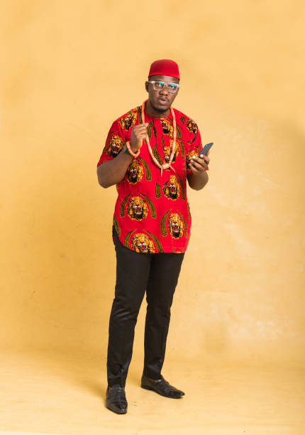 istock Igbo Traditionally Dressed Business Man Standing with Phone in Hand Looking 1385668190
