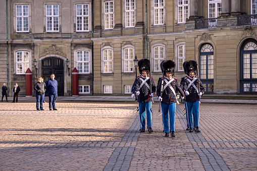 Changing of the royal guard outside the royal palace Amalienborg in Copenhagen. The change of the guard is very popular pastime for tourists who are enjoying the ritual at close range. The royal palace is build in 1760 and consists of four similar palaces, inhabited by the different generations of the royal family