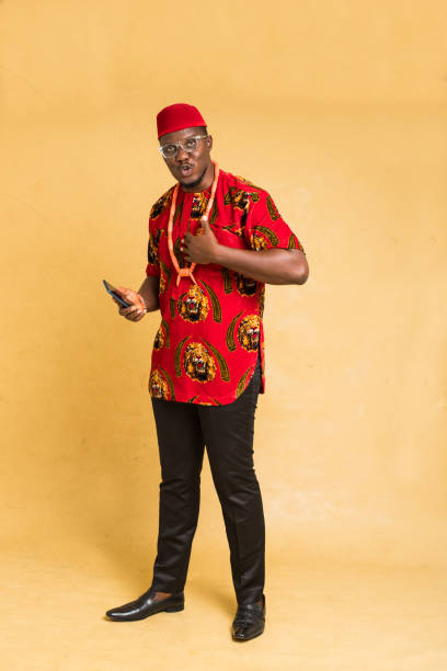 istock Igbo Traditionally Dressed Business Man Standing with Phone in Hand 1385668261