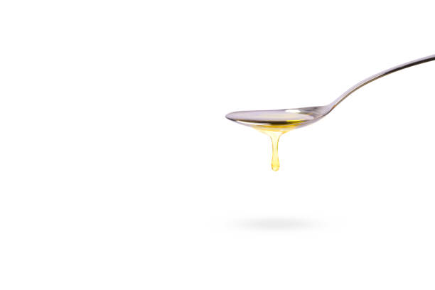 Oil drop dripping from stainless steel spoon Oil drop dripping from stainless steel spoon isolated on white background. Side view, Copy space. olive oil pouring antioxidant liquid stock pictures, royalty-free photos & images