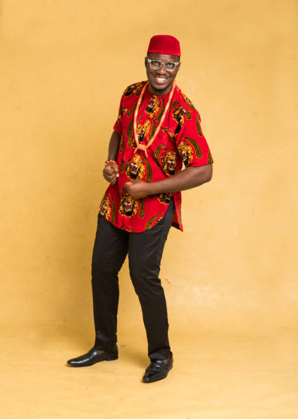 igbo traditionally dressed business man standing and posturing happily - nigeria african culture dress smiling imagens e fotografias de stock