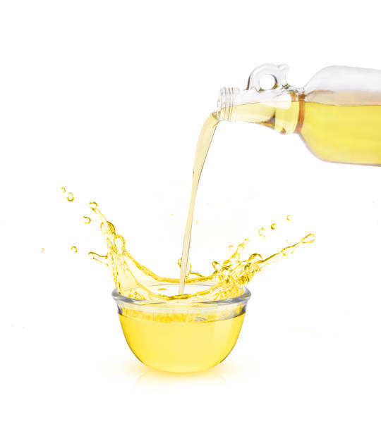 olive oil pouring from bottle into bowl  on white - olive oil pouring antioxidant liquid imagens e fotografias de stock
