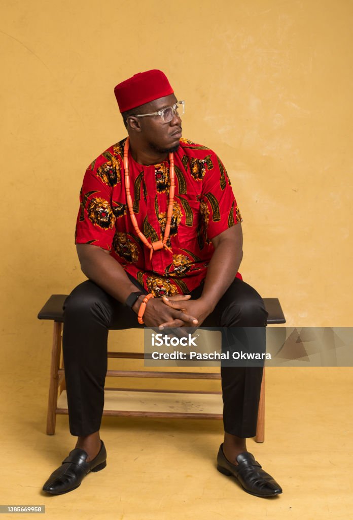Igbo Traditionally Dressed Business Man Sitting Down and Look to the Side Adult Stock Photo